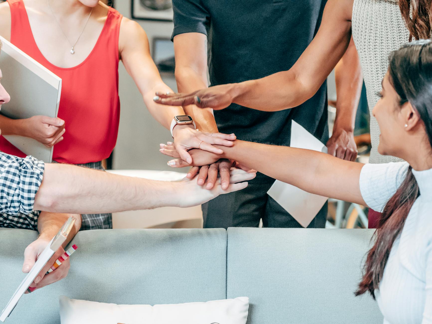 Zespół pracowników w biurze łączy dłonie na znak współpracy