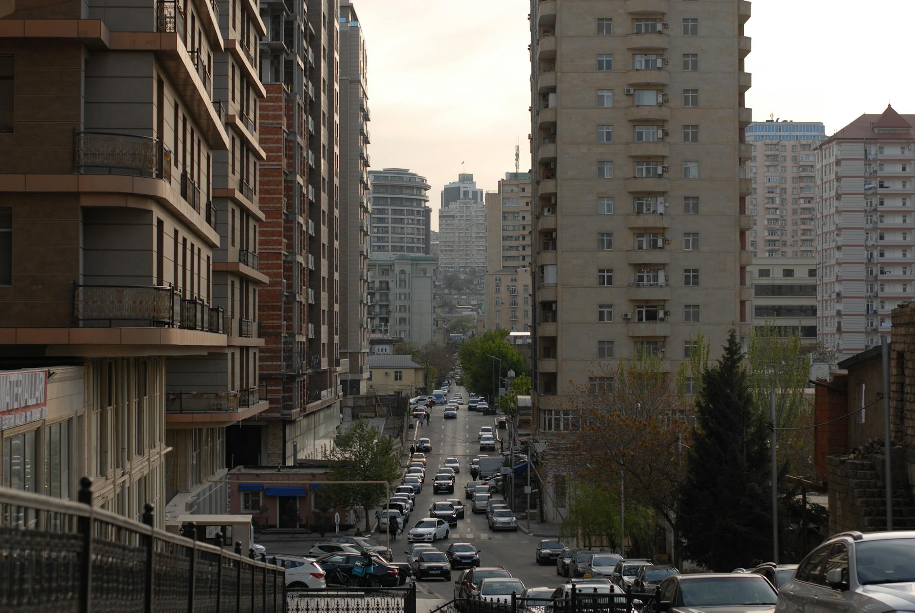 Ruchliwa ulica Katowic wśród wysokich budynków o zachodzie słońca