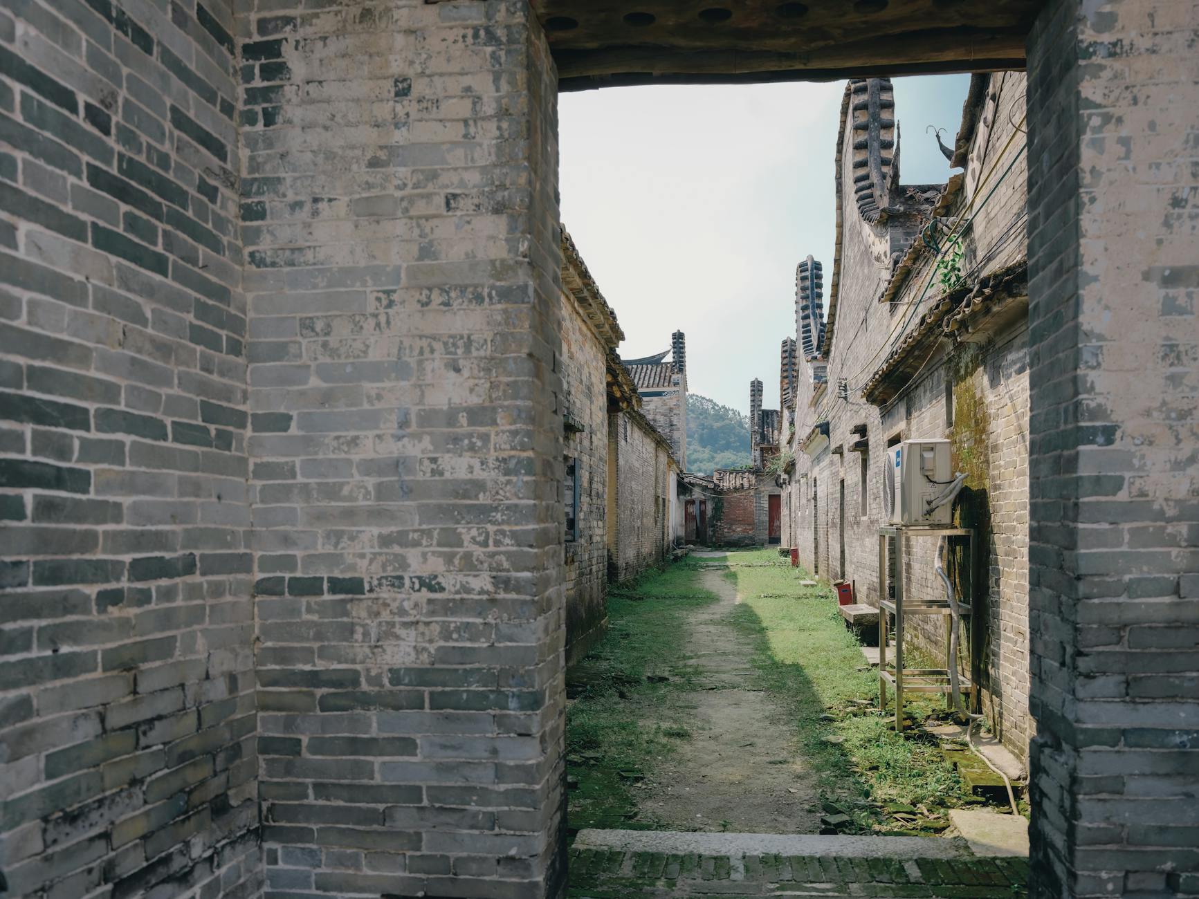 Wąska kamienna uliczka między historycznymi ceglanymi kamienicami