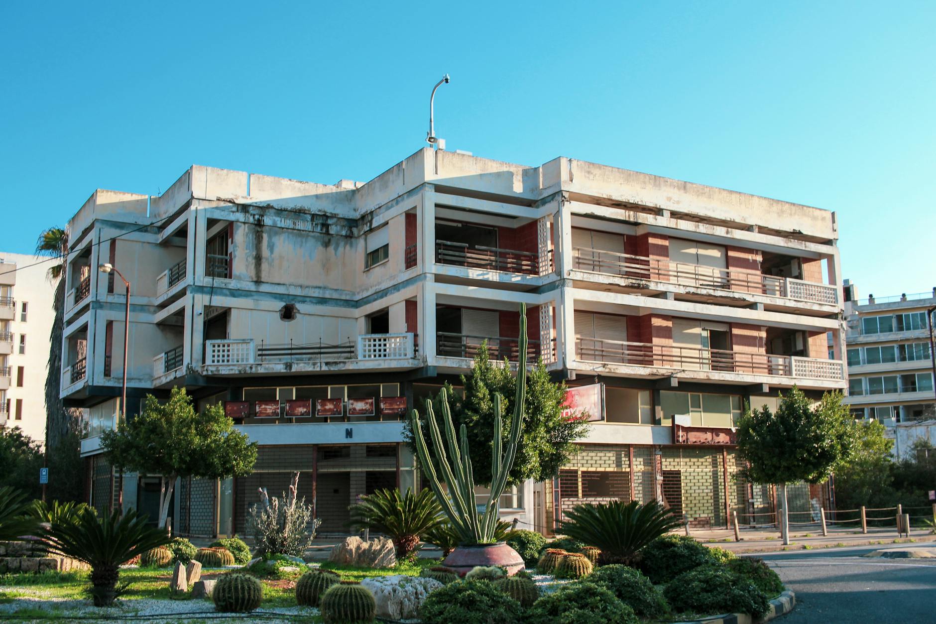 Zaniedbana kamienica otoczona zielenią na tle katowickiej zabudowy